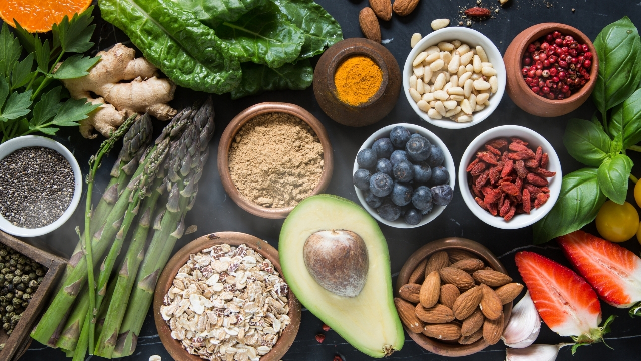 A colorful bowl of fertility-boosting foods including spinach, avocado, nuts, and whole grains for natural fertility before IVF.